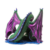 Figurine of green dragon with purple wings and blue spines on a water base with a rune at the center of its coils. View from the back