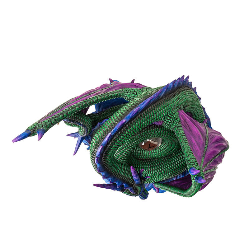 Figurine of green dragon with purple wings and blue spines on a water base with a rune at the center of its coils. Top down view