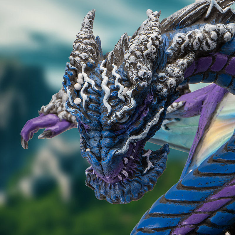 Figurine of dragon in blue and purple, rainbow wings, gray bubbles, closeup of head