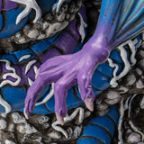 Figurine of dragon in blue and purple, rainbow wings, gray bubbles, closeup of hand