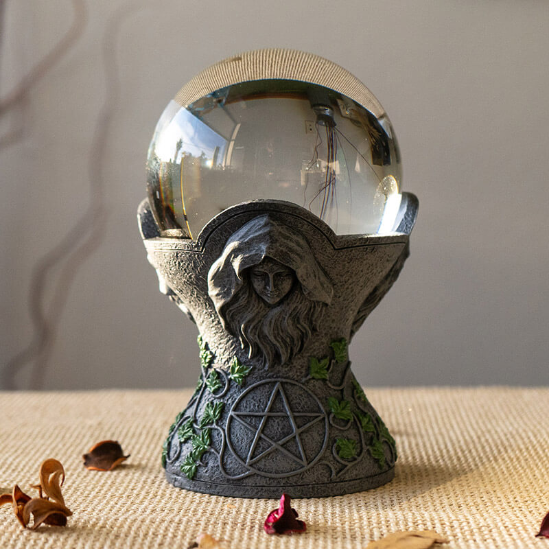 Crystal ball on a faux-stone stand with the maiden, mother & crone, leaf & pentacle designs