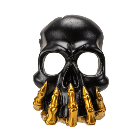 Black skull with golden boney hand candleholder