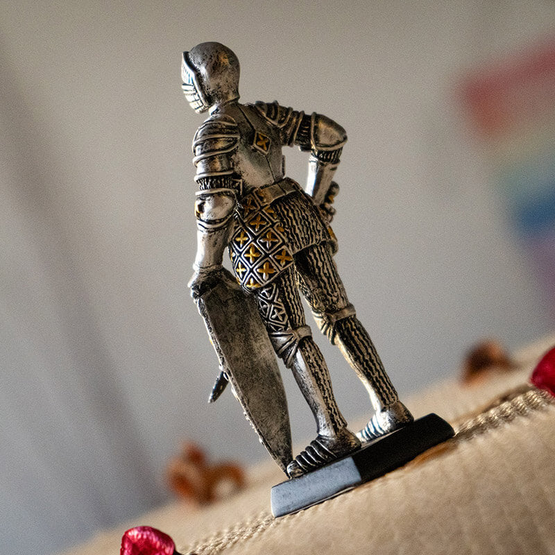 Figurine of knight in silver and gold armor with sword and lion rampant shield