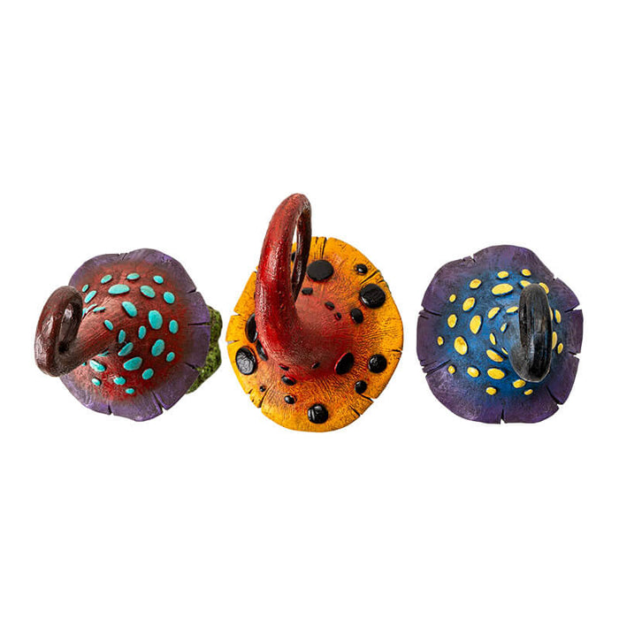Set of three mushroom figurines. One is burgundy and purple with blue dots and stem, one is red and yellow with black dots, third is blue and violet with yellow spots.