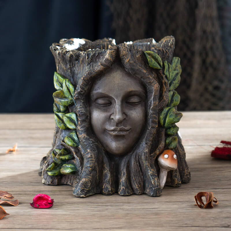 Flower planter of a tree ent, serene face surrounded by leaves and mushrooms on a faux-tree