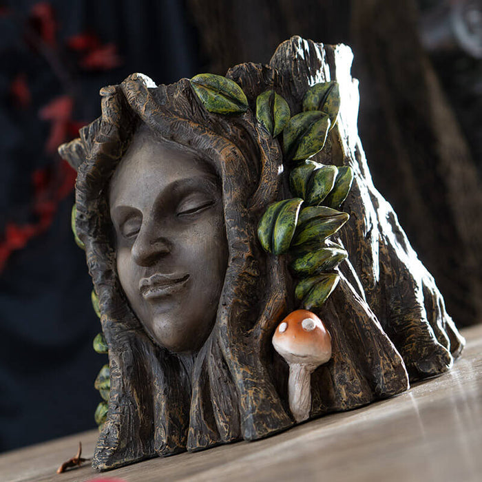 Flower planter of a tree ent, serene face surrounded by leaves and mushrooms on a faux-tree