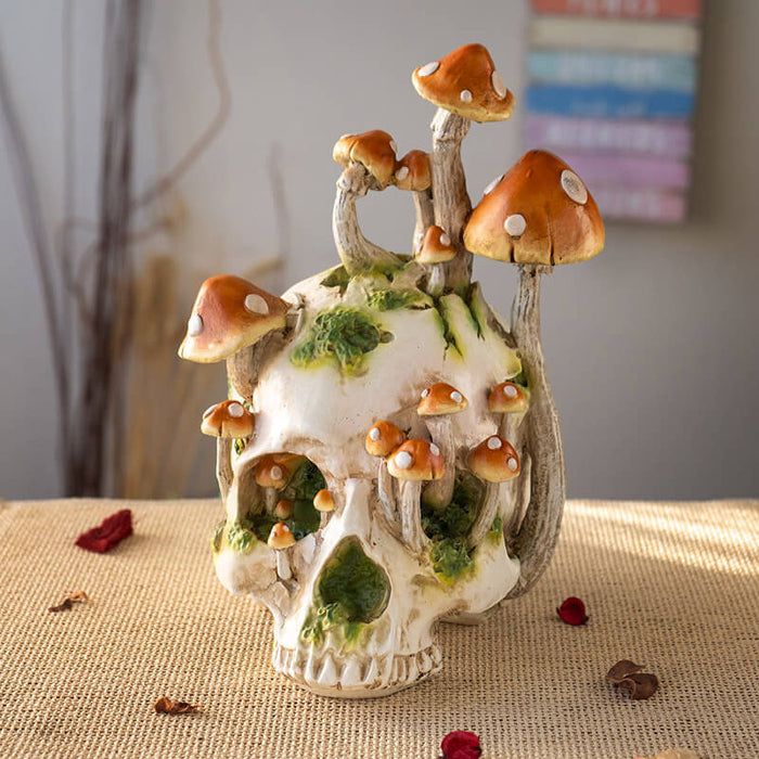 Grinning Skull figurine with mushrooms growing out of it and moss