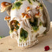 Grinning Skull figurine with mushrooms growing out of it and moss