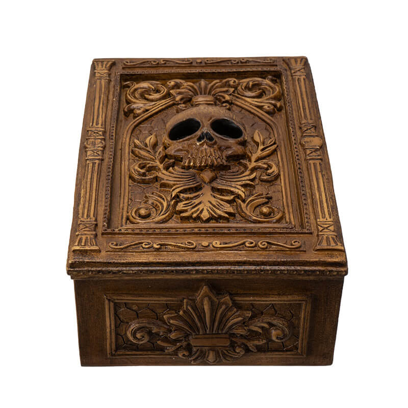 Tarot or trinket box in brown hue with skull and elaborate designs on lid, more fleur de lis emblems on the side.