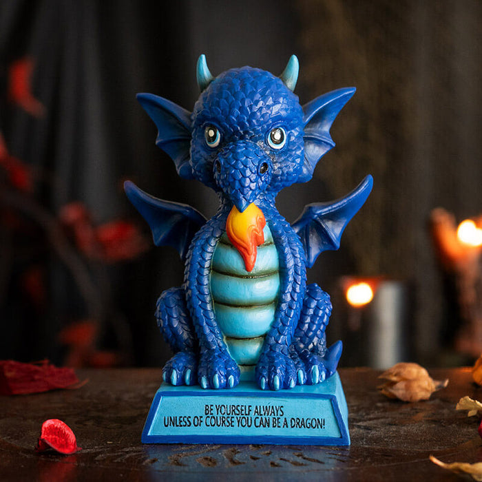 Figurine of a dragon sitting on a blue base that says "BE YOURSELF ALWAYS UNLESS OF COURSE YOU CAN BE A DRAGON!" The dragon is shades of blue with a little burst of fire.