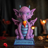 Figurine of a pink dragon with blue tummy and horns and a flame, sitting on indigo base that reads "She's cute but fierce!"