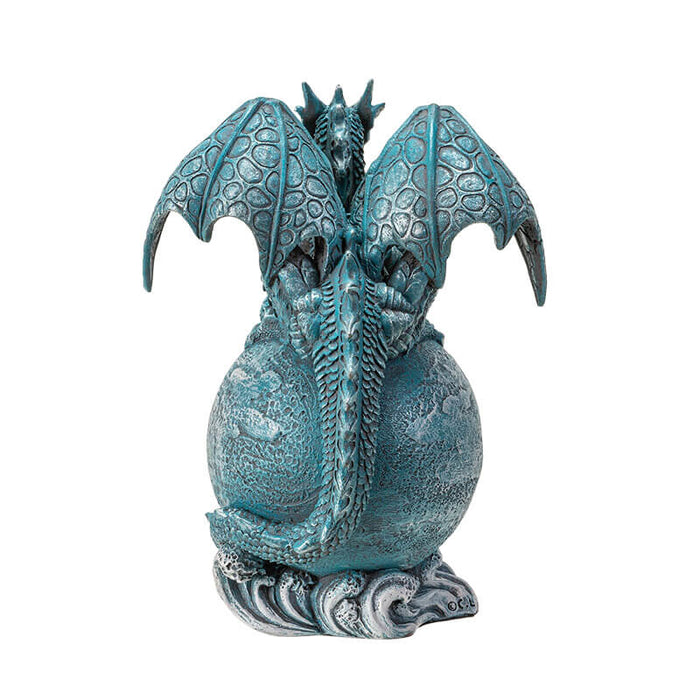 Figurine of a blue dragon on the planet Uranus with tail coiled around and water waves below. Back view