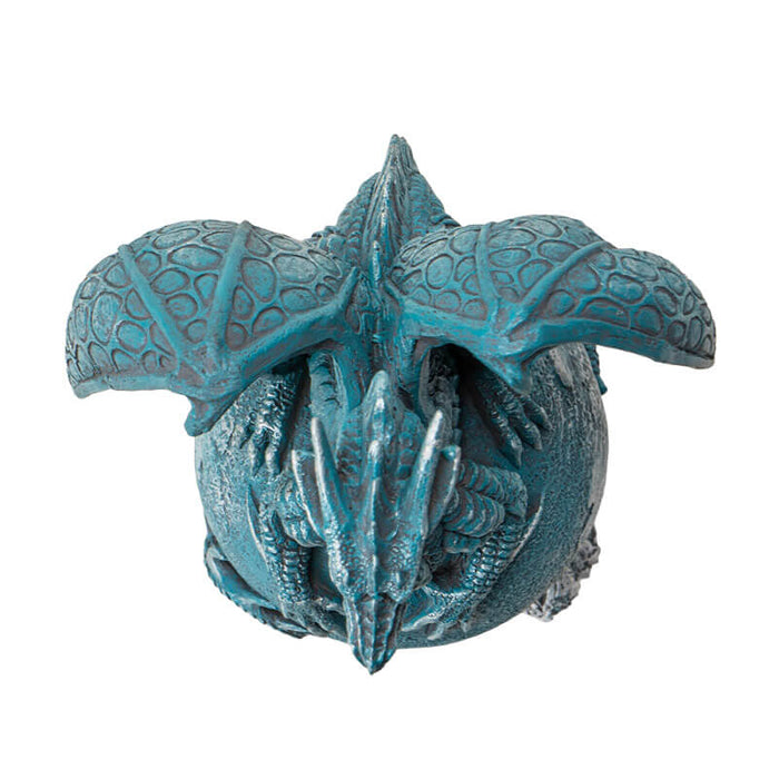Figurine of a blue dragon on the planet Uranus with tail coiled around and water waves below. Top down view
