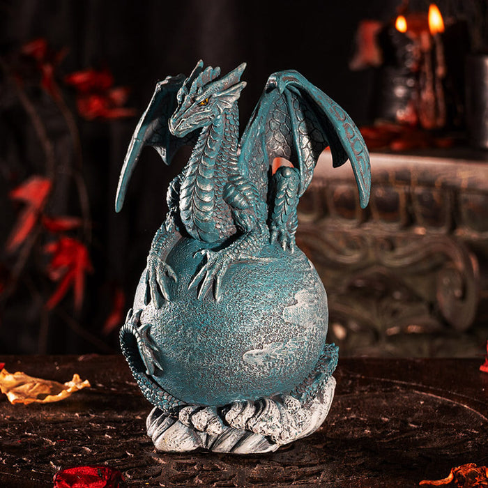 Figurine of a blue dragon on the planet Uranus with tail coiled around and water waves below