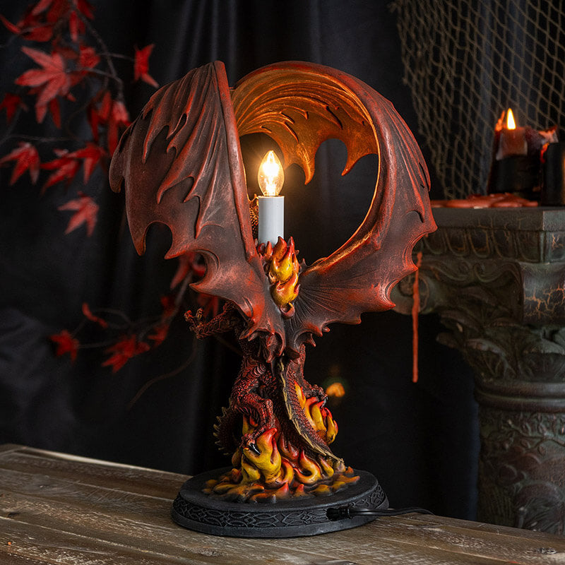 Corded lamp with red dragon with fire on a Celtic base, lightbulb in the back below curled wings.