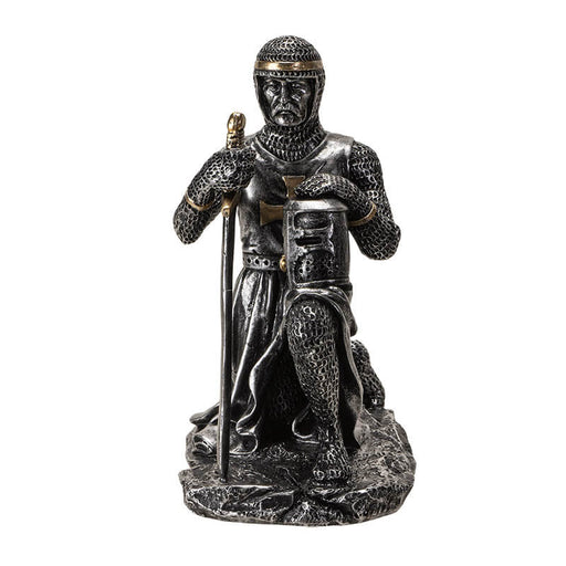 faux-metallic figurine of a medieval knight kneeling, holding helm and sword, wearing chainmail with gold accents