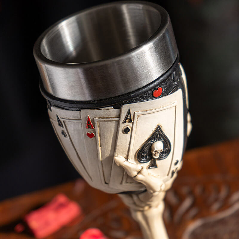 Goblet with stainless steel drinking insert. Skeletal hands hold four cards, showing both the backs and the aces on a poker-themed base.