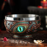 Bowl with aqua dragon eye design, red accents on black, and stainless steel insert