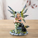 Figurine of fairy with green wings and striped stockings, and black cat ears. Holding a butterfly with a black winged fairy cat next to her