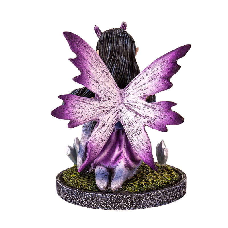 Figurine of a purple winged and dress fairy kneeling with a crystal ball and gems growing next to her, shown from the back