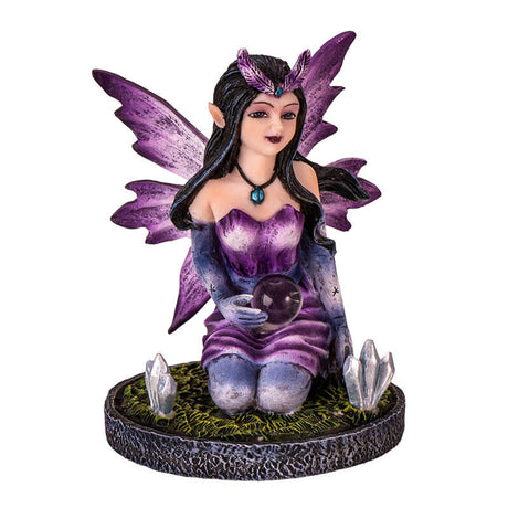 Figurine of a purple winged and dress fairy kneeling with a crystal ball and gems growing next to her