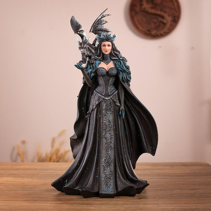 Figurine of a woman in black and blue dress with glitter and flowing cape, and a black and blue dragon on her shoulder.