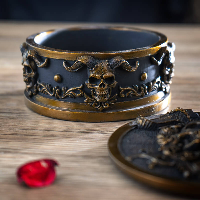 Trinket box with gold horned skulls on black background