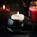 Black ceramic curled up cat tealight candle holder, shown with candle as example