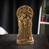 Faux-stone figurine in ivory color with triple goddess - maiden, mother, and crone standing together under a triple moon design - waxing, full and waning. At their feat is a cauldron and sheaf of wheat.