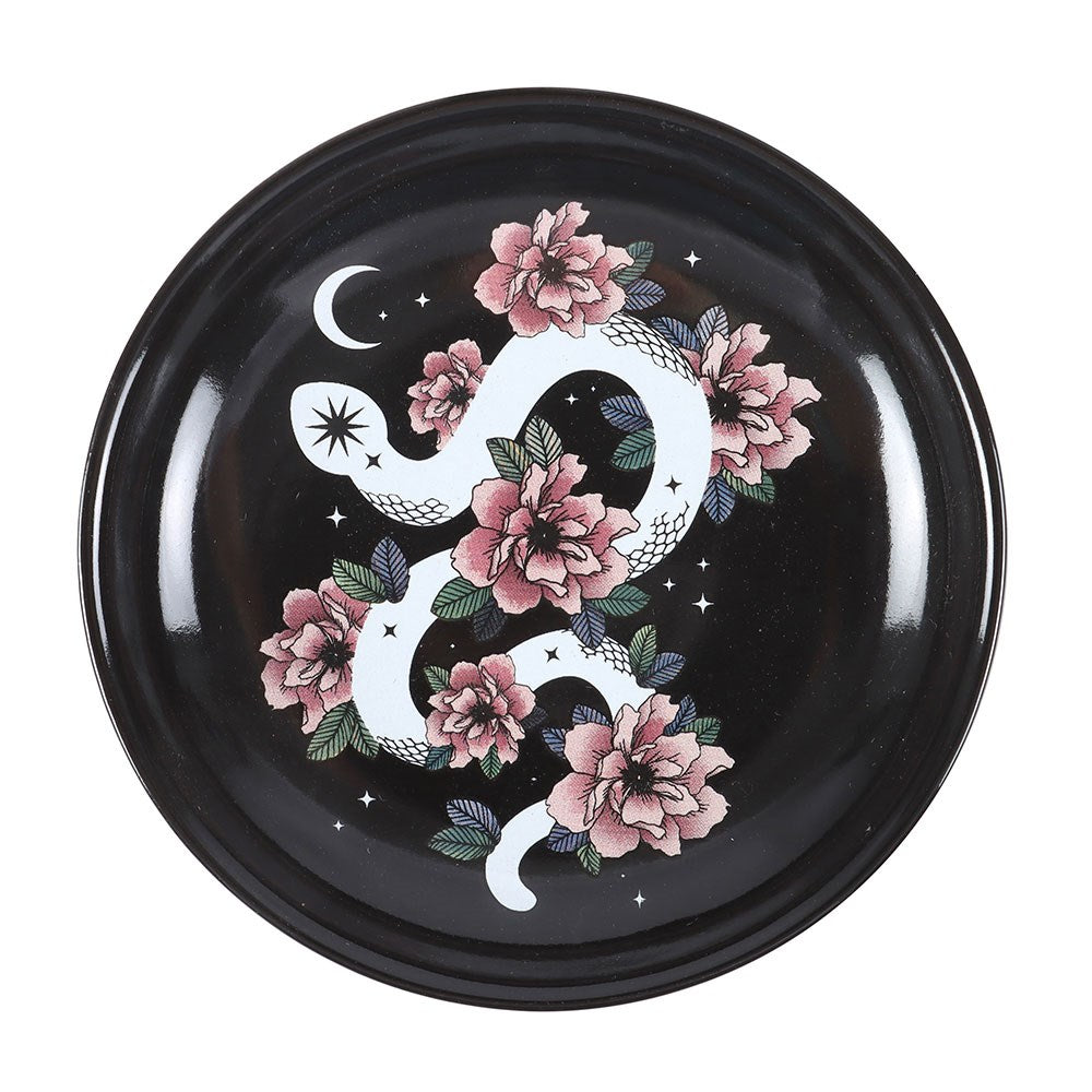 Trinket dish showing white snake with crescent moon, pink flowers on black ceramic background