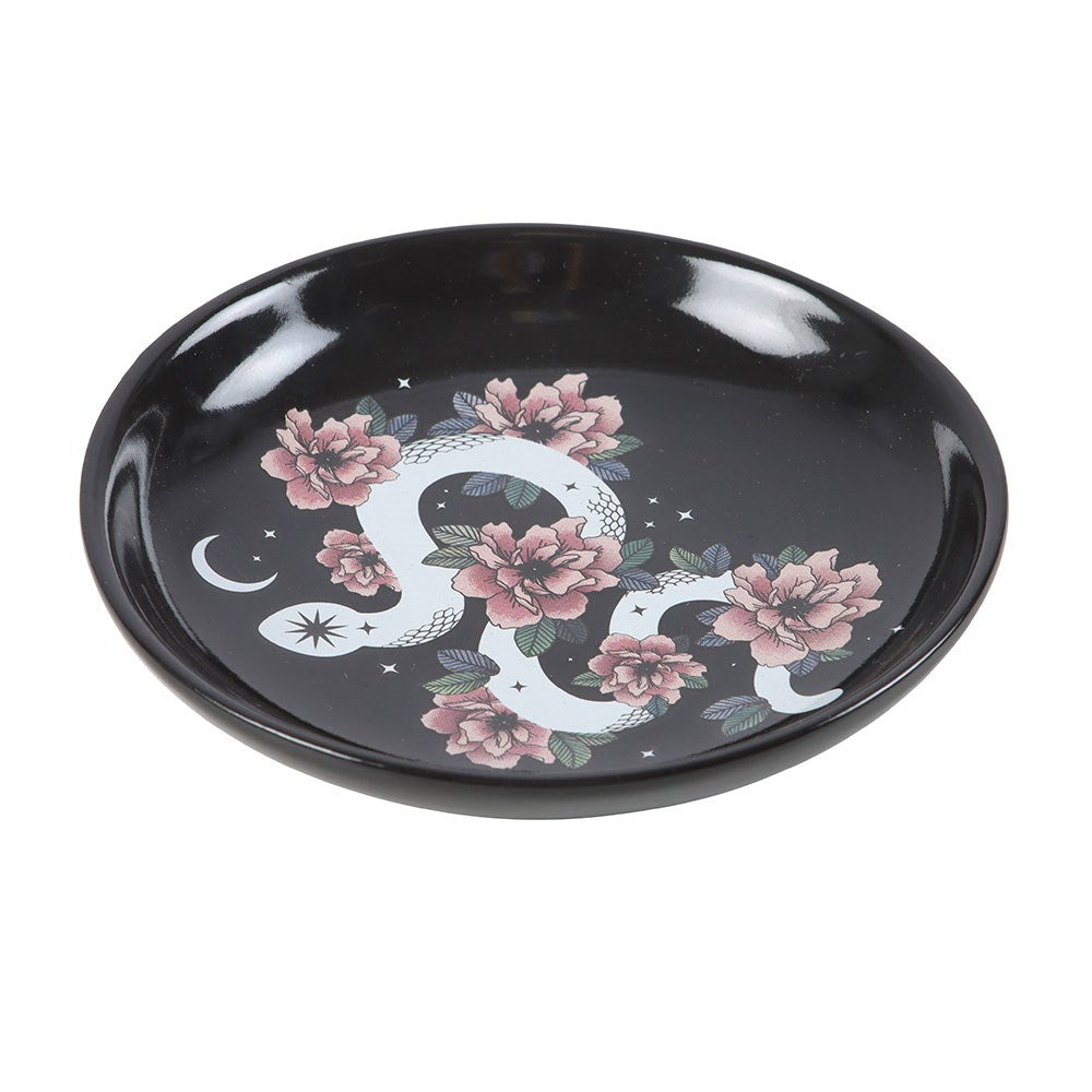 Trinket dish showing white snake with crescent moon, pink flowers on black ceramic background