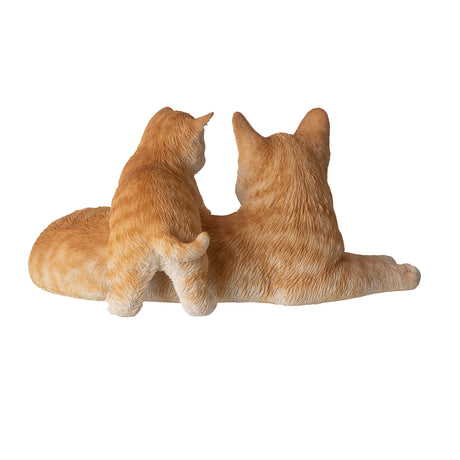 Orange striped mother cat lying down with kitten climbing on, shown from the back, cute cat tail seen