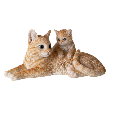 Orange striped mother cat lying down with kitten climbing on