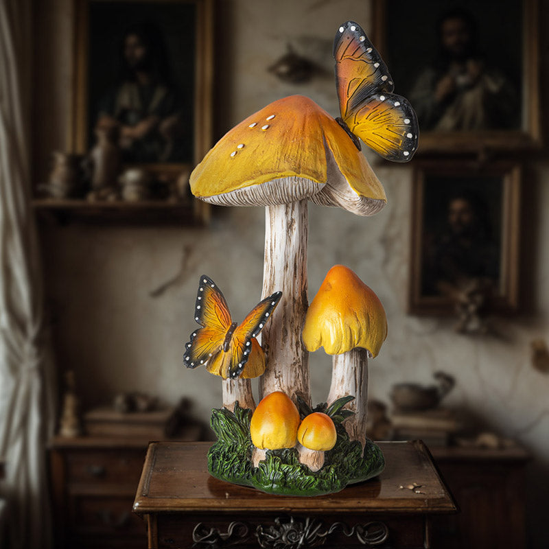 Figurine of yellow-topped mushrooms growing from grass/moss with two yellow-orange and black butterflies