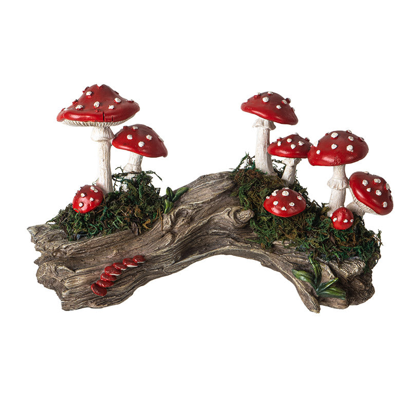 Red capped and white toadstools growing along a mossy faux=wood log stump