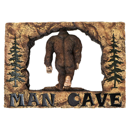 Wall plaque showing Bigfoot walking away, framed in faux rock with trees and words "Man Cave"