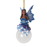 Hanging fairy ornament with dark skinned pixie, black hair, blue dress with purple skirt. Striped blue and white stockings, blue wings, perched upon a glass bubble