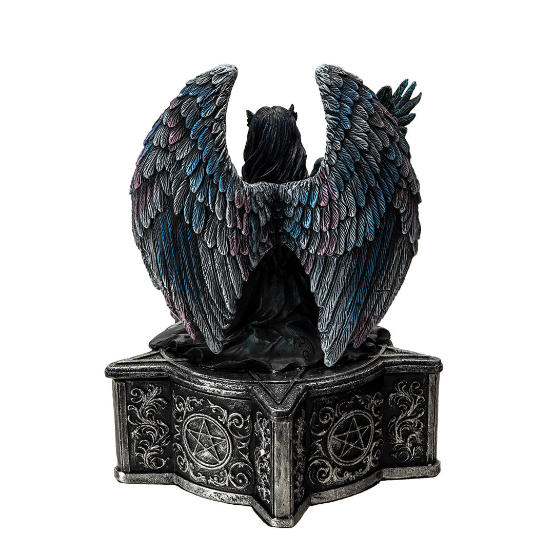 Trinket box, on the lid is a black feather winged angel with a raven on her arm, blue-black dress, black hair, mask. Base of box has pentacle designs. Shown from the back