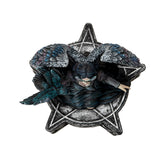 Trinket box, on the lid is a black feather winged angel with a raven on her arm, blue-black dress, black hair, mask. Base of box has pentacle designs. Shown top down