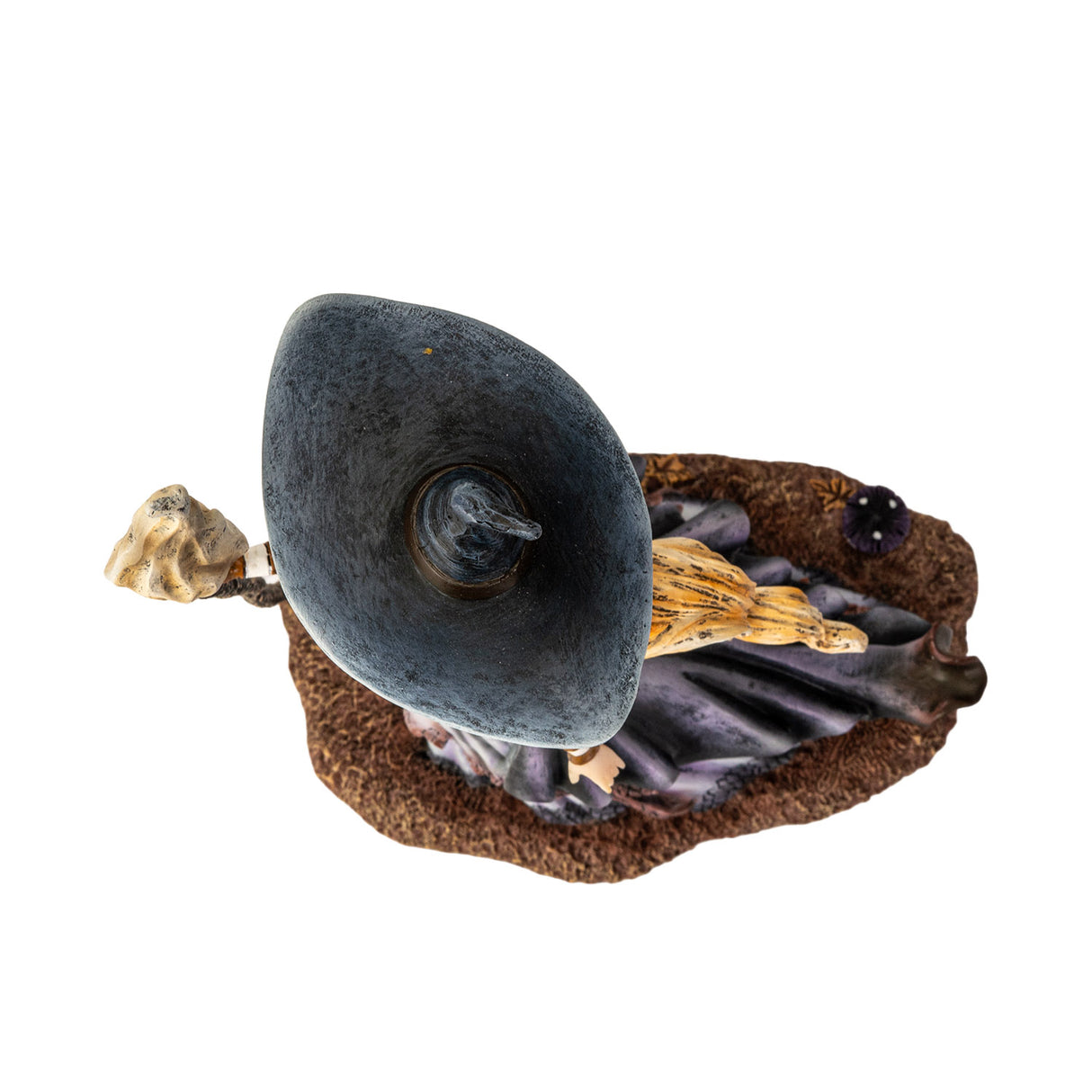 Figurine of blond witch with broom, mushrooms at her feet, shown top down