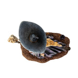 Figurine of blond witch with broom, mushrooms at her feet, shown top down