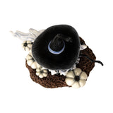 Halloween-themed figurine of a witch with white pumpkins and a ghost and bat, shown top down