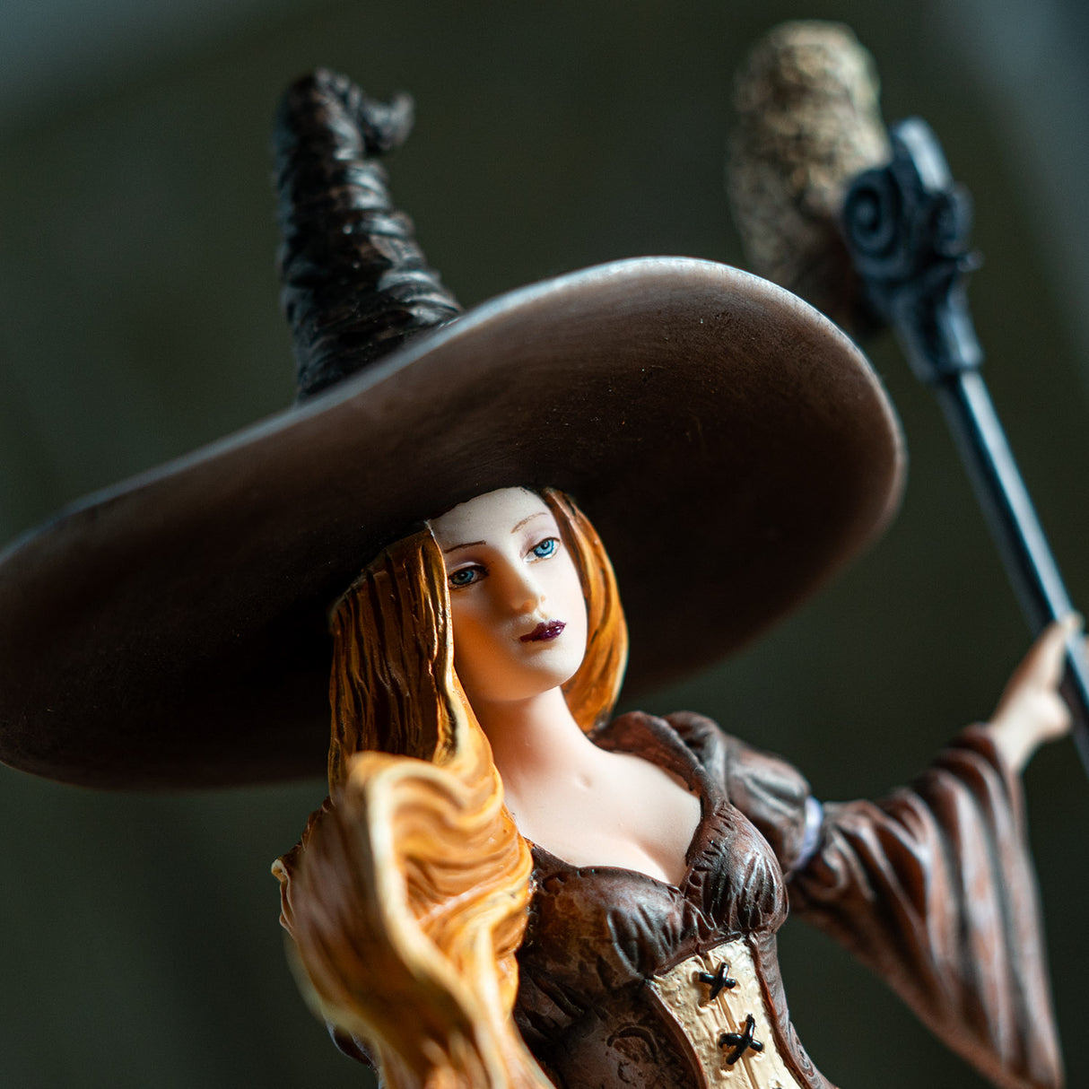 Closeup of witch figurine, red hair, blue eyes