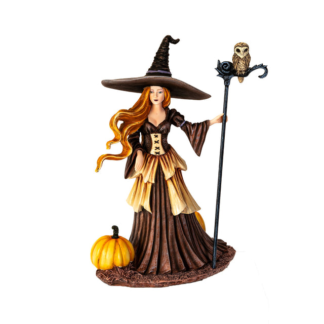 Figurine of witch with red hair, brown dress, surrounded by pumpkins, owl perched on her staff