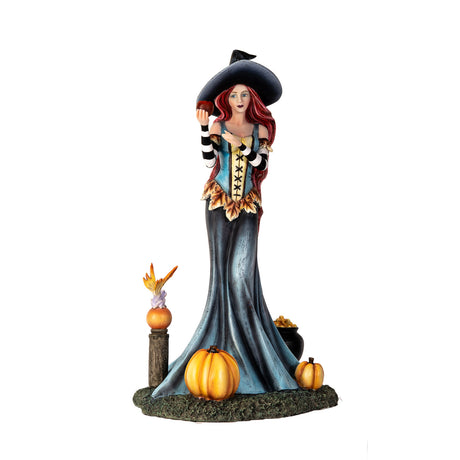 Figurine of witch holding apple, at her feet are pumpkins, fairy frog, cauldron of fruit