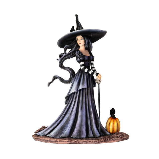 Figurine of a witch in a moody dress and big hat, her hair billowing in an unseen breeze. Next to her is a festive pumpkin, and perched upon it and on her hat are ravens