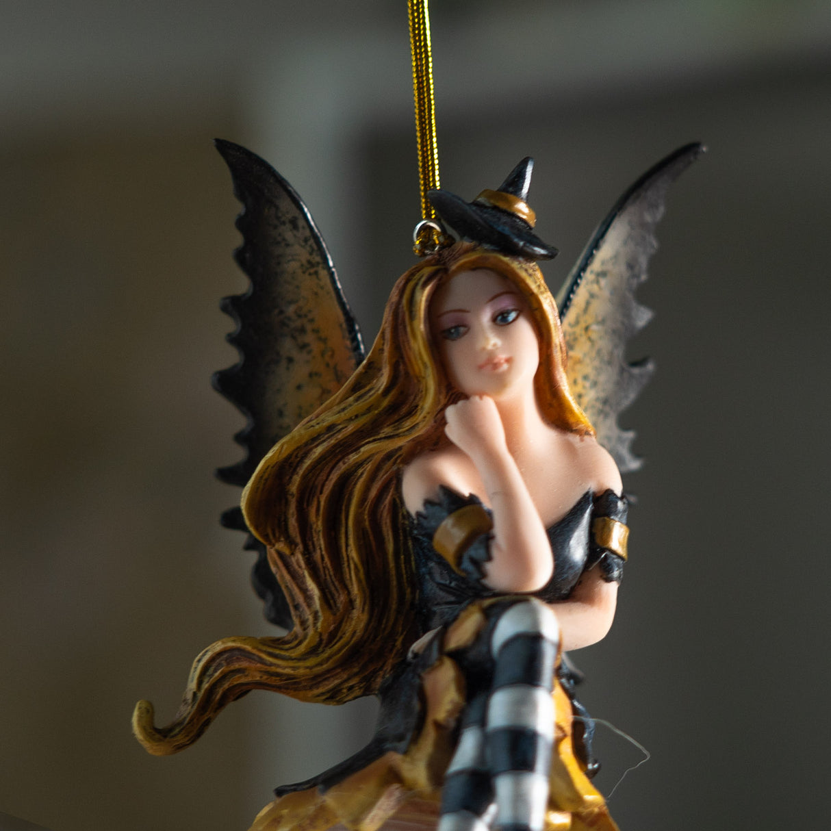 Fairy ornament with witch-themed attire perched on a glass bubble