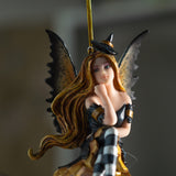 Fairy ornament with witch-themed attire perched on a glass bubble