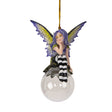 Fairy ornament with purple hair and striped pants sitting on a clear glass ball. Purple and yellow wings, gazing out