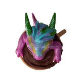 Colorful dragon figurine sitting inside a Cappuccino cup on a white background, shown top down